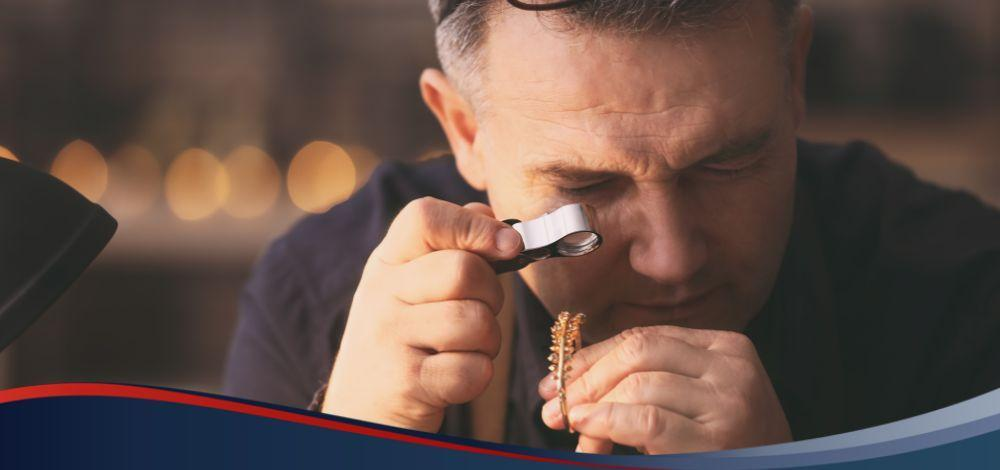 A pawnbroker assessing a gold bracelet in a pawnshop lending