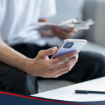 Photo of a man using his phone to apply a loan online
